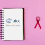 UICC logo on a notebook next to a pink ribbon