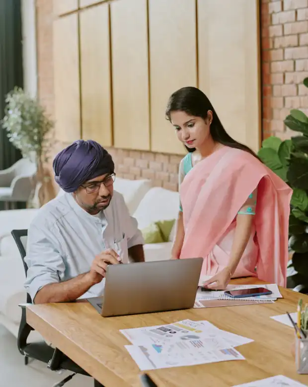 Business professionals discussing content on a computer, representing Marathi language services